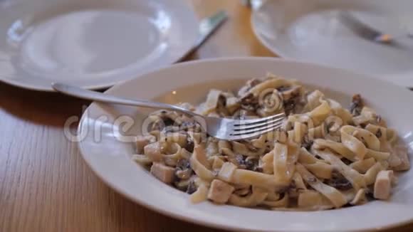 意大利意面酱蘑菇和罗勒叶慢动作视频有鸡肉和鸡肉的意大利面食视频的预览图