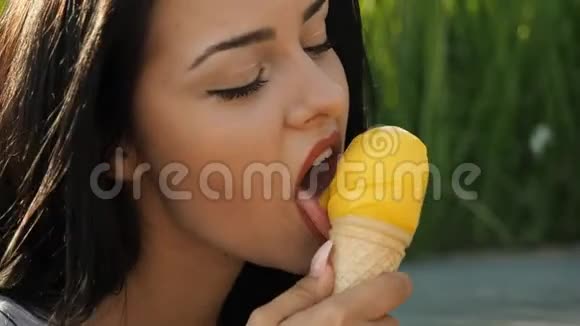 年轻美女微笑着在高清电视里吃冰淇淋视频的预览图