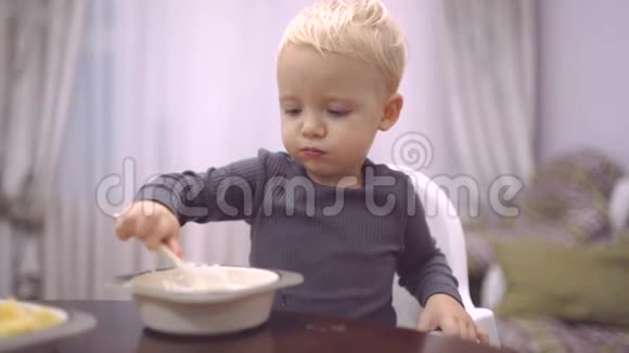 食物和饮料儿童饮食概念小男孩在厨房吃早餐快乐的小男孩勺子吃自己视频的预览图