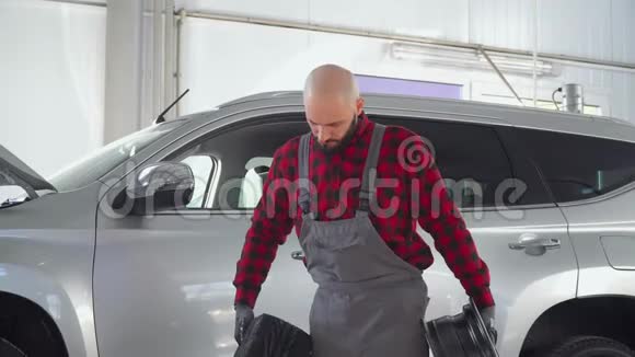 机械师在车库里拿着轮胎汽车修理厂的专业技工在客车上更换车轮视频的预览图