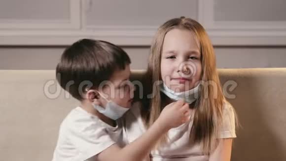 有趣的孩子一个男孩和一个女孩把呼吸面具放在他们的嘴和鼻子上预防非典视频的预览图