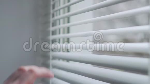 一个戴防护面罩的女人看着窗外视频的预览图