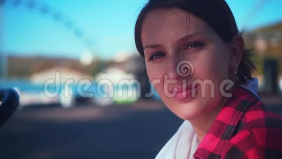 一个穿着黑红色格子衬衫的迷人女孩的肖像女孩看着摄像机微笑着视频的预览图