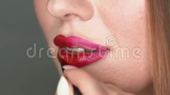 女人用红色口红宏观的特写镜头视频的预览图