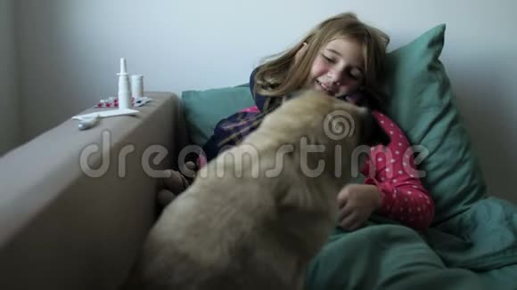 生病的小美丽的女孩带着围巾和她的狗在床上女孩身边有药品喷鼻剂视频的预览图