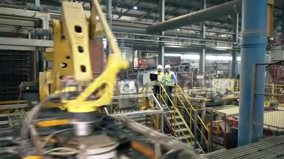 工厂设施有两名工人和机械设备视频的预览图