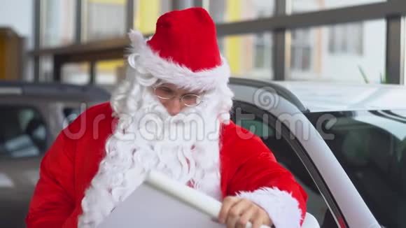 一家汽车经销店的圣诞老人在名单上了一些东西视频的预览图