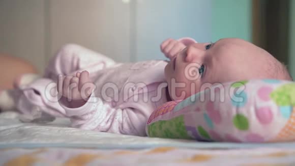 刚出生的女婴一个新生婴儿躺在床上的骨科枕头上女孩把目光移开视频的预览图