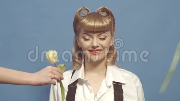 兴奋的女孩带着金色的别针头发挽着郁金香美丽快乐的年轻女人圣爱的象征爱的概念视频的预览图
