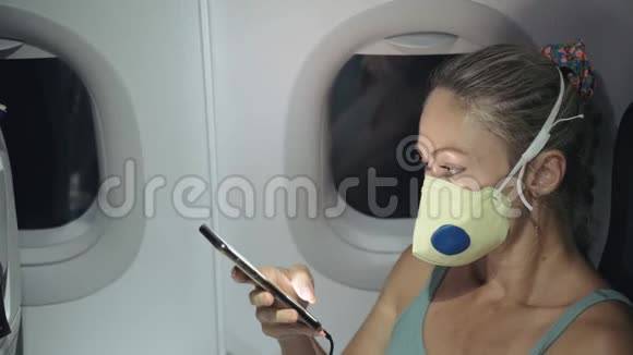 女旅游白种人在飞机上戴着防护医疗面罩阅读有关鸡冠状病毒的震惊新闻视频的预览图