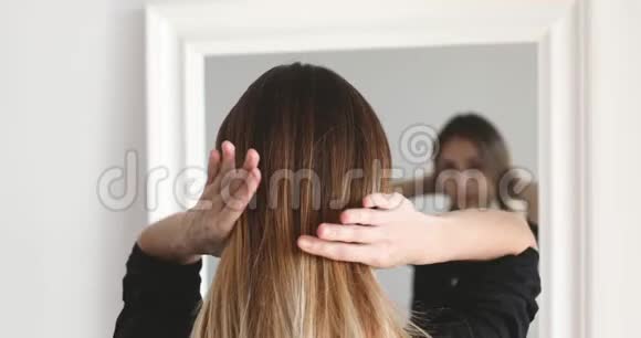女孩或女人在镜辫前做发型视频的预览图