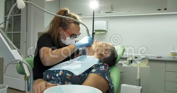 女牙医为老年妇女病人做牙科治疗视频的预览图