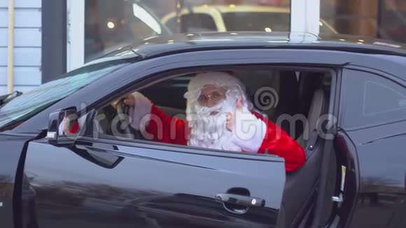 圣诞老人在一辆黑色跑车展示了和平的姿态视频的预览图