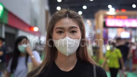 戴防护面罩的妇女站在展览中并感染病毒视频的预览图