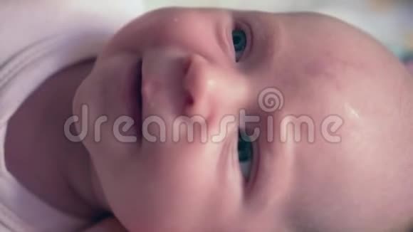 刚出生的女婴的肖像一个新生婴儿躺着看着远方宝贝第一情感微笑视频的预览图
