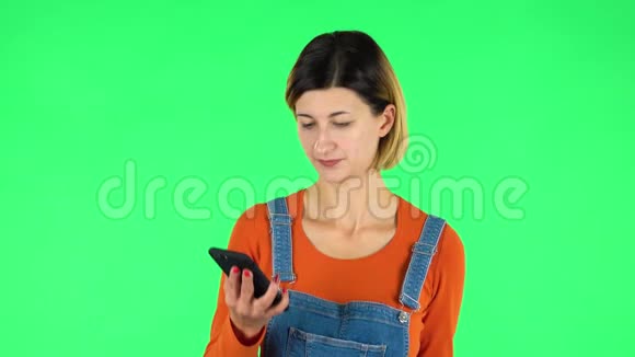 女孩用手机聊天视频绿色屏幕视频的预览图