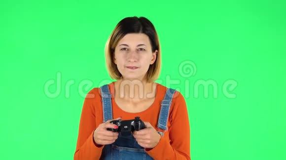 女孩玩电子游戏使用无线控制器与喜悦和失败绿色屏幕视频的预览图