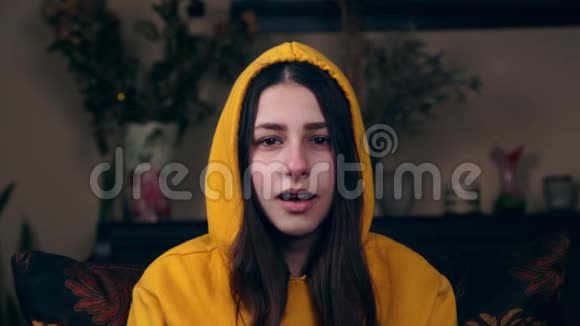 一个年轻的欧洲女孩很累在家里的扶手椅上打哈欠疲劳的概念视频的预览图
