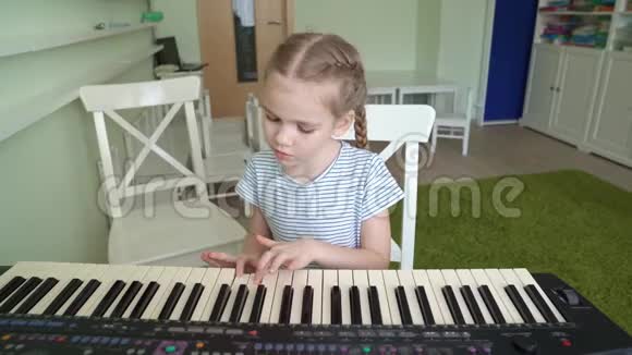 一个小女孩学会玩合成器视频的预览图