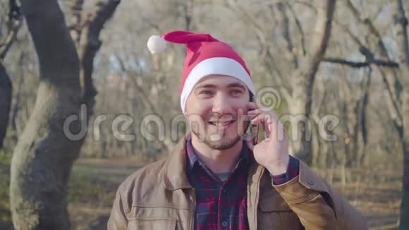一个戴着新年帽子的人在打电话呼吁并祝圣诞快乐视频的预览图