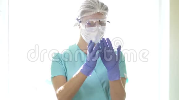 护士戴着医用口罩和安全眼镜戴上一次性手套医务人员个体防护视频的预览图
