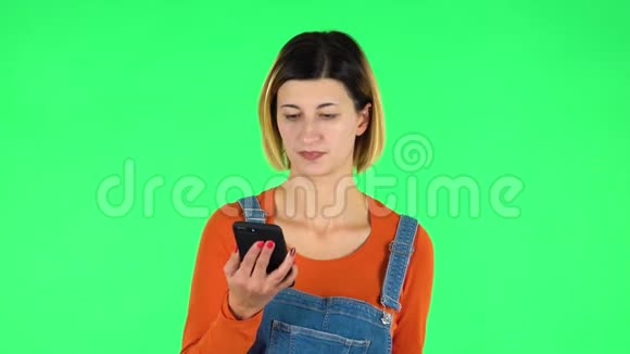女人通过电话说话看起来很无聊绿色屏幕视频的预览图