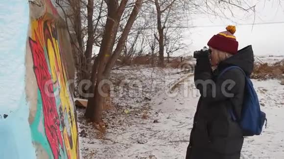一个女孩在冬天在墙上涂鸦女游客在街上拍照视频的预览图