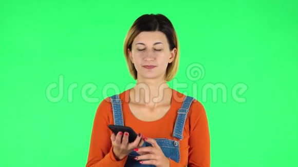 女孩在绿色屏幕上通过电话询问网络信息视频的预览图