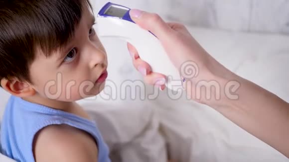 母亲用无接触装置测量小孩的体温视频的预览图