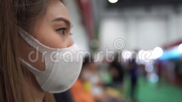 戴防护面罩的妇女站在展览中并感染病毒视频的预览图
