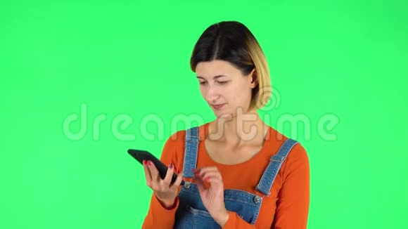 微笑的女孩用手机聊天视频绿色屏幕视频的预览图