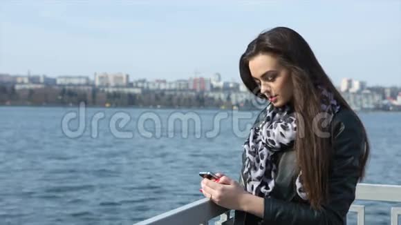 女孩在海滩上写短信视频的预览图