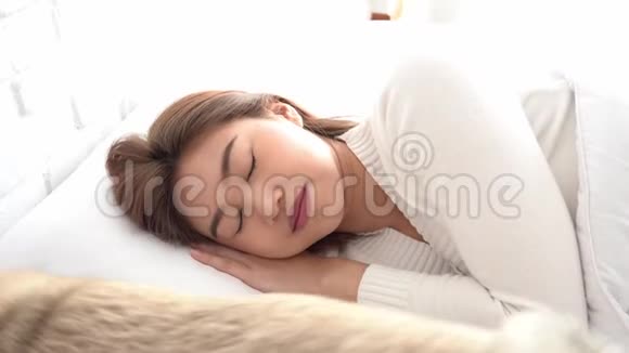 亚洲女人穿着睡衣睡觉闭上眼睛微笑睡觉狗醒着视频的预览图