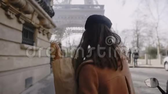 美丽快乐的欧洲女人走在埃菲尔铁塔附近给镜头男人一个缓慢的动作视频的预览图