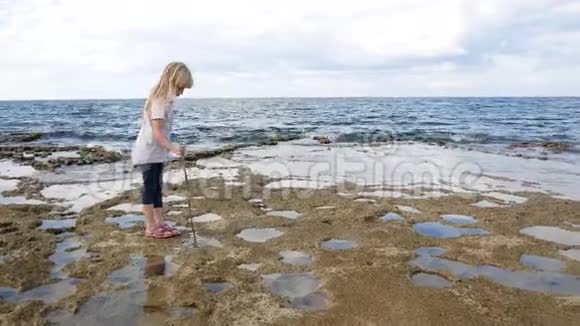 一个金发女孩正在地中海沿岸寻找宝藏视频的预览图