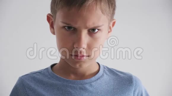 年轻的白种人孩子皱着眉头看着愤怒双臂交叉在白色背景上视频的预览图