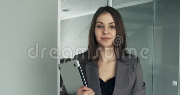 年轻的商务女性走在办公室走廊里有魅力的女性会带着笔记本和视频的预览图
