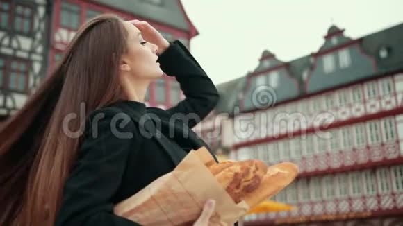 穿着黑色夹克的漂亮德国女孩笨拙地握着纸包的手视频的预览图