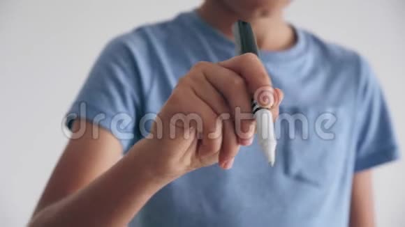十几岁的男孩站着用笔在空中写东西视频的预览图