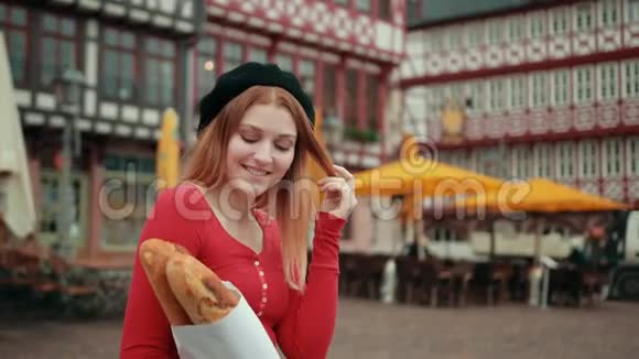 身穿黑色贝雷帽的法国女孩拿着纸包的面包竖起大拇指视频的预览图