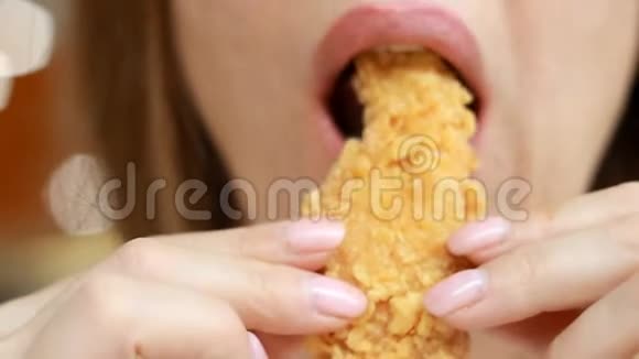 女人吃金块快餐鸡块咖啡馆里的翅膀特写镜头视频的预览图