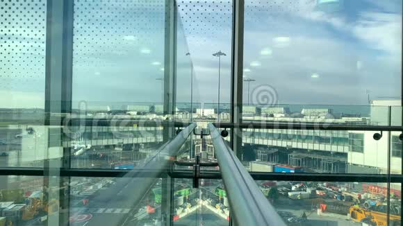 一位带背包的女游客站在机场休息室望着窗外旅行理念视频的预览图
