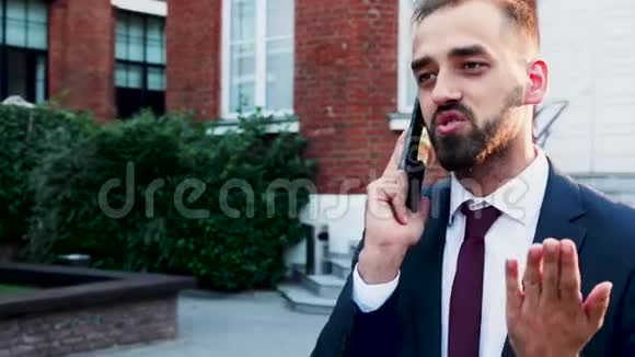 穿着商务服的男人打电话在城市户外视频的预览图