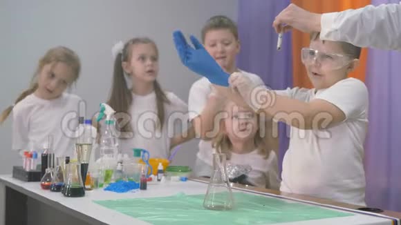 儿童化学实验一个女人在烧瓶中加入化学实验的成分一列烟升起视频的预览图