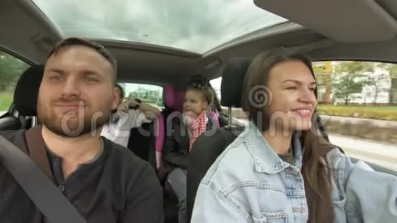 男人和女人带着孩子开车两个父母和孩子在运输途中旅行和跳舞快乐视频的预览图