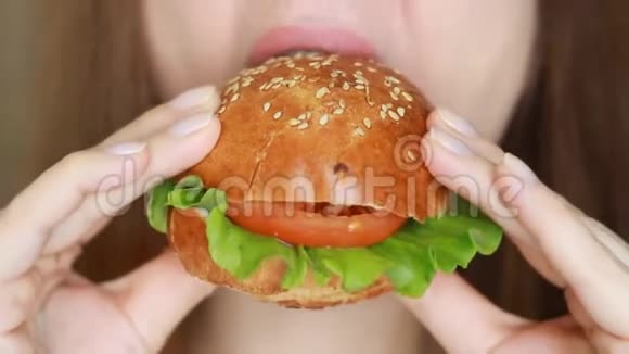 女人咬着汉堡特写女人吃汉堡包视频的预览图