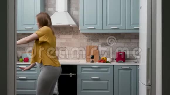 快乐怀孕20岁的女人妈妈在家里的厨房里跳舞放松烹饪吃4K视频的预览图
