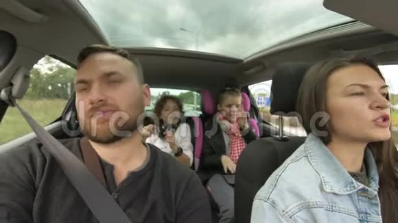 男人和女人带着孩子开车两个父母和孩子在运输途中旅行和跳舞快乐视频的预览图