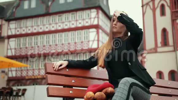 穿夹克的女人坐在长凳上长条面包裹着纸视频的预览图