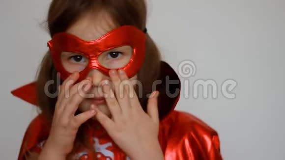 超级英雄可爱的宝贝女孩有趣的孩子穿着红色雨衣和面具玩权力超级英雄肖像特写视频的预览图